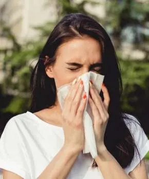 Młoda kobieta w praku ma kaszel i alergię (fot. istockphoto.com)